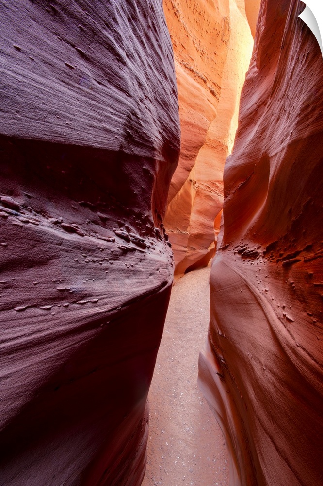 A photograph through a narrow canyon corridor.