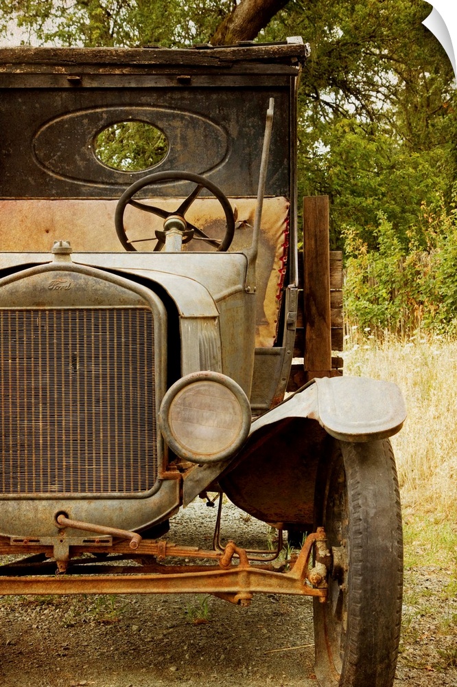 Photograph of a derelict truck sitting in a clearing in the countryside.
