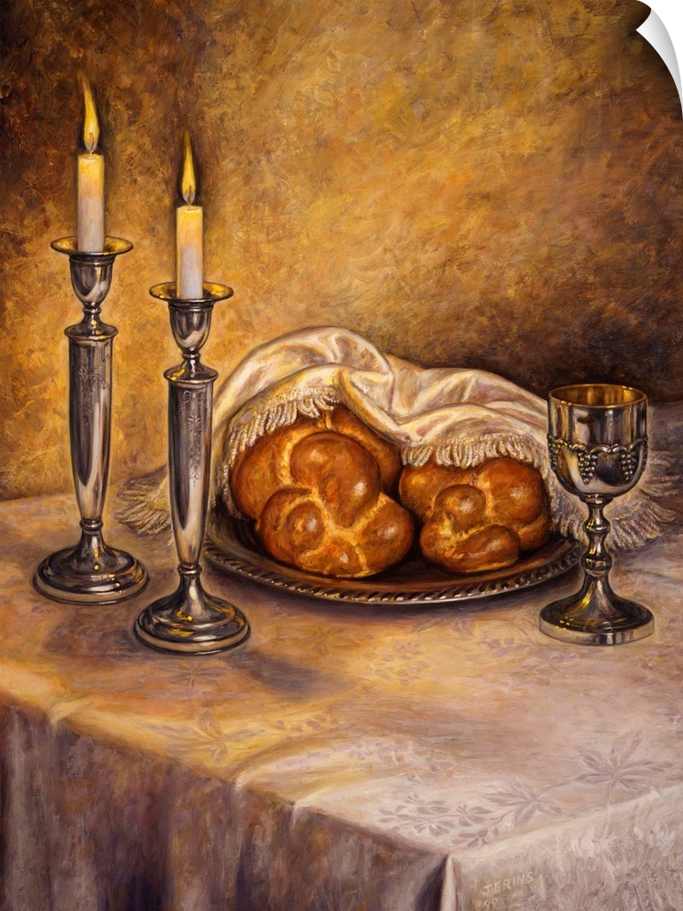 A table with two lit candles and two loaves of bread, covered by a towel, a wine glass on the table
