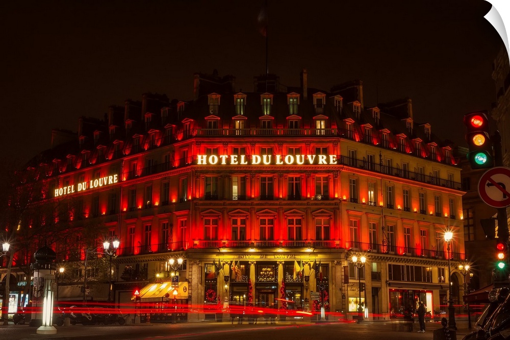 A photograph of the Hotel du Louvre at night.