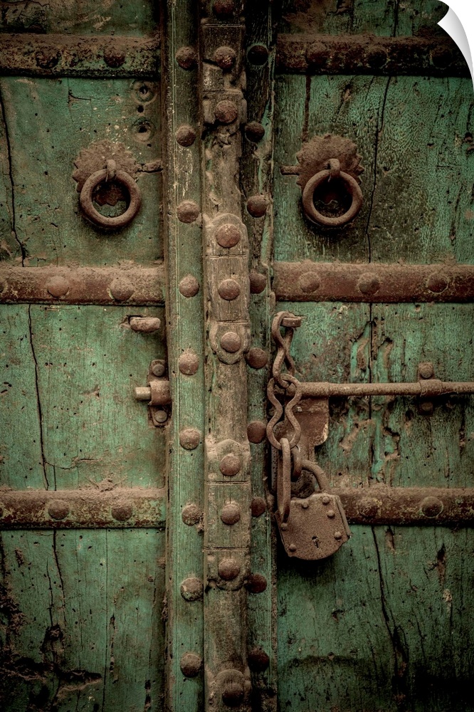 Photograph of an old antique door with a large chain lock and bolts.