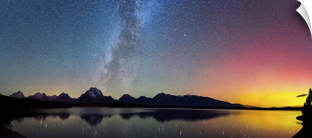 Aurora Borealis and the Milky Way visible in the sky over a lake.