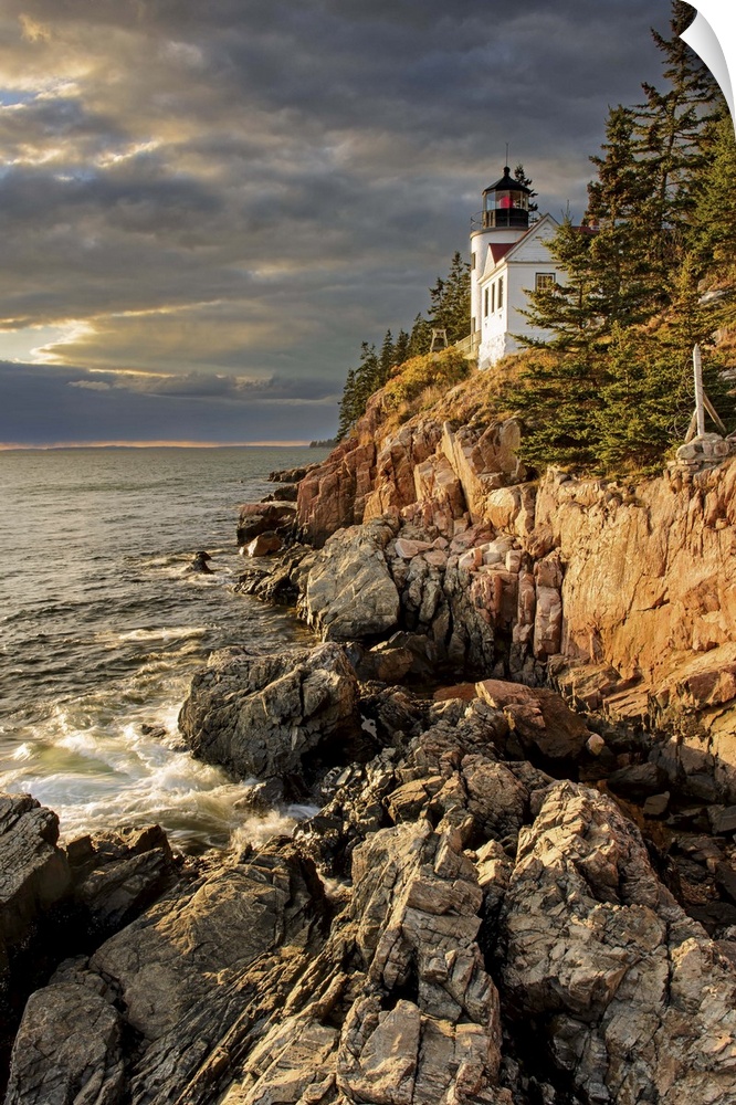 A photograph of a lighthouse on a rocky escarpment on the coastline.