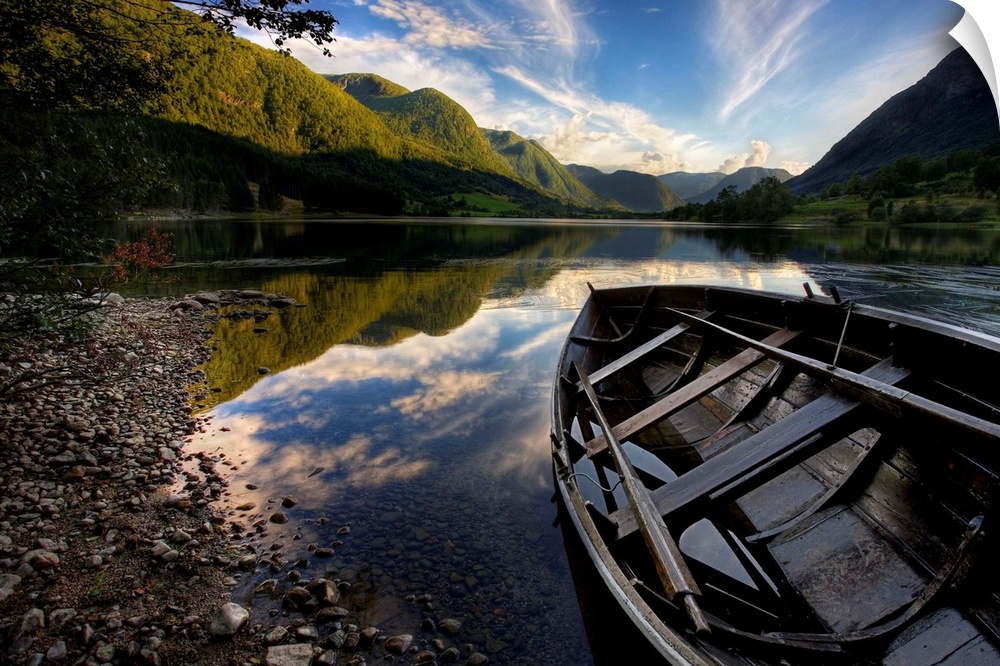 Row boat resting on the shore with mountains in the background