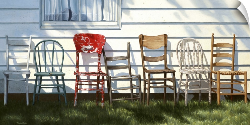 Row of wooden chairs lined up in front of a house.