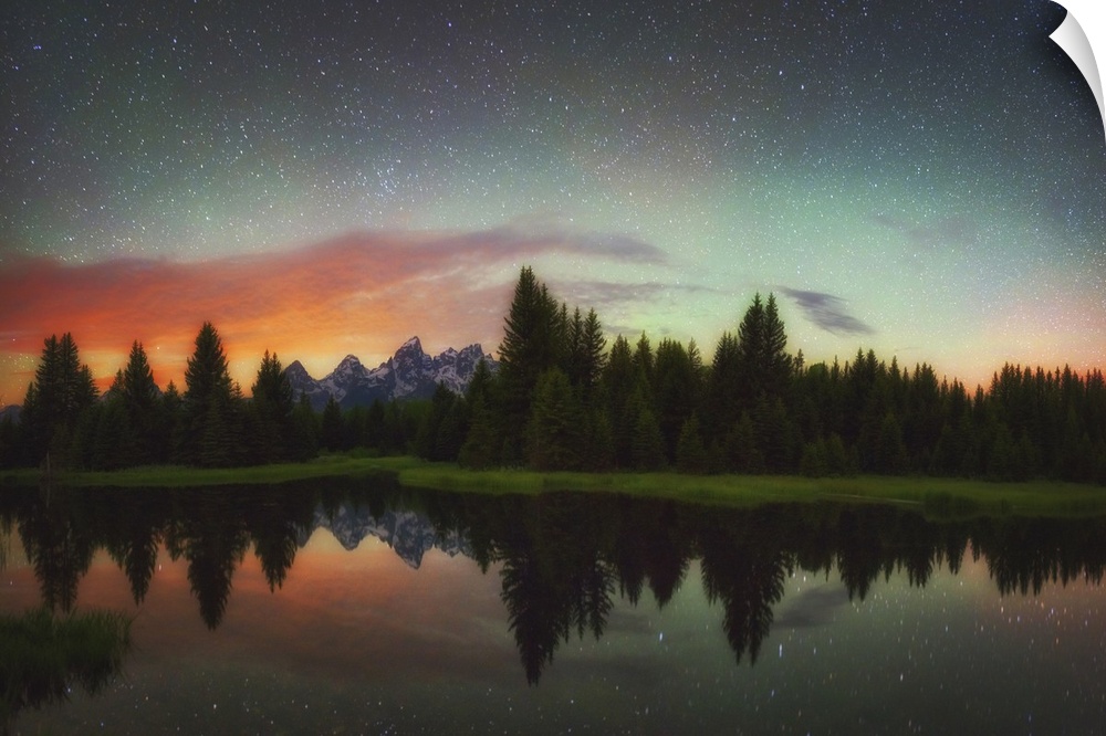 A vividly colored night sky over the mountains and forest.