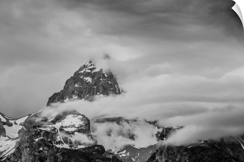 Black and white photograph of a cloudy mountain peak.