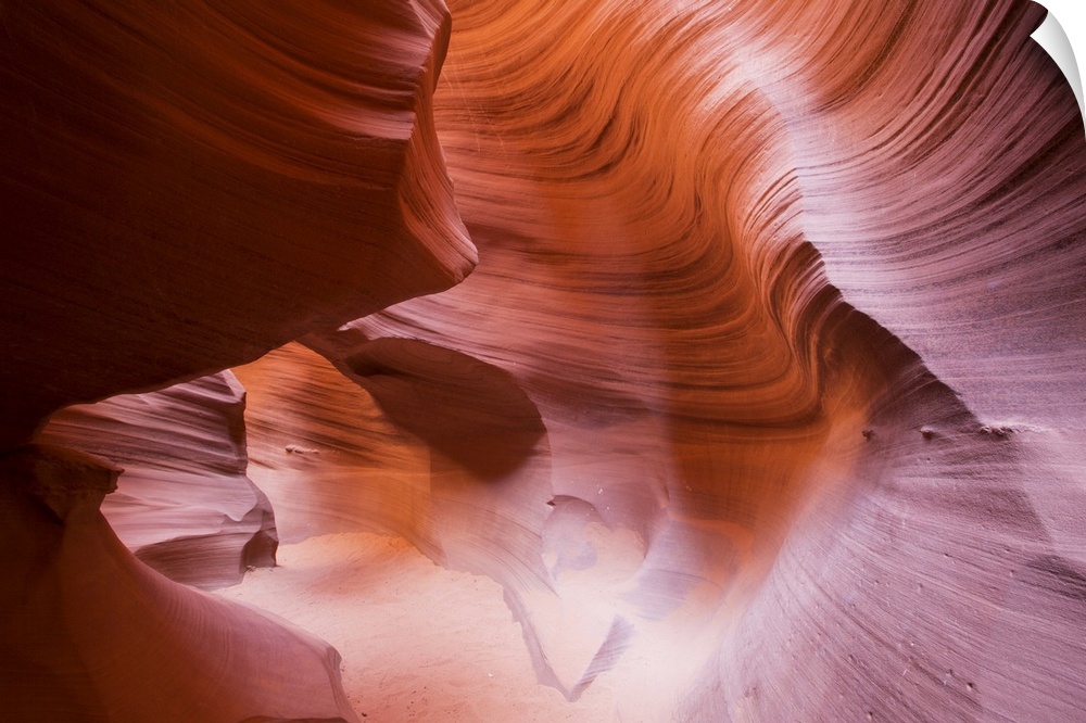 This picture is taken inside of a canyon where the rock has ridges and a curve like design.