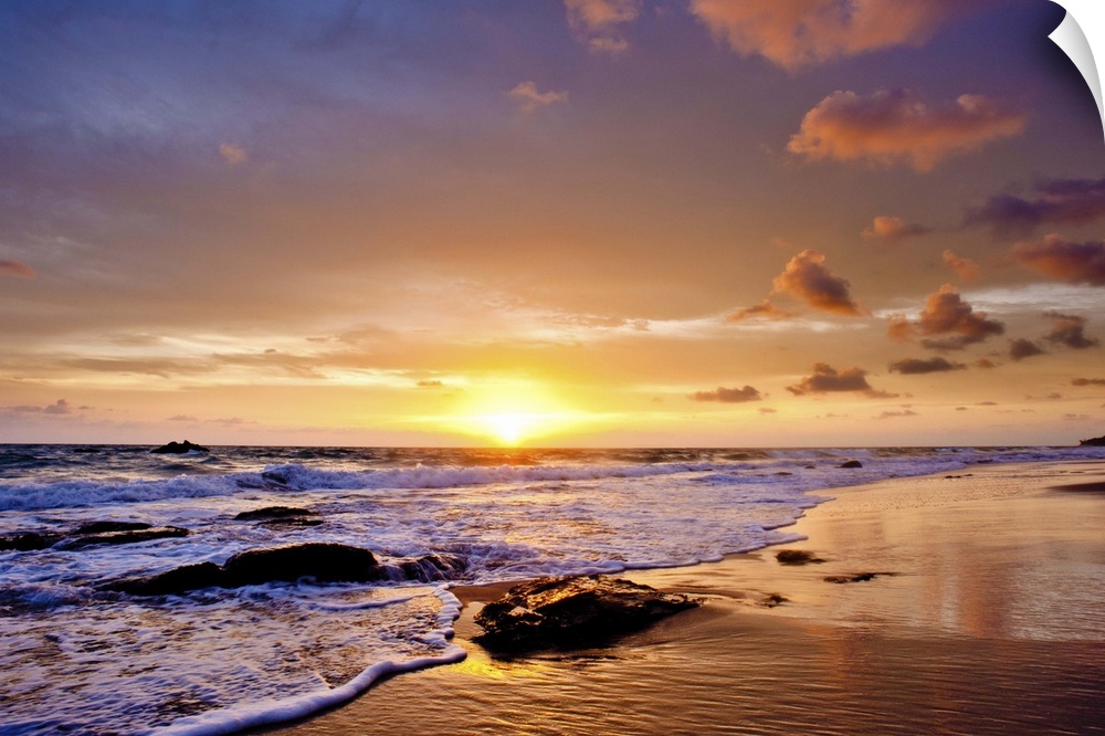 A photograph of a seascape seen from a beach at sunset.