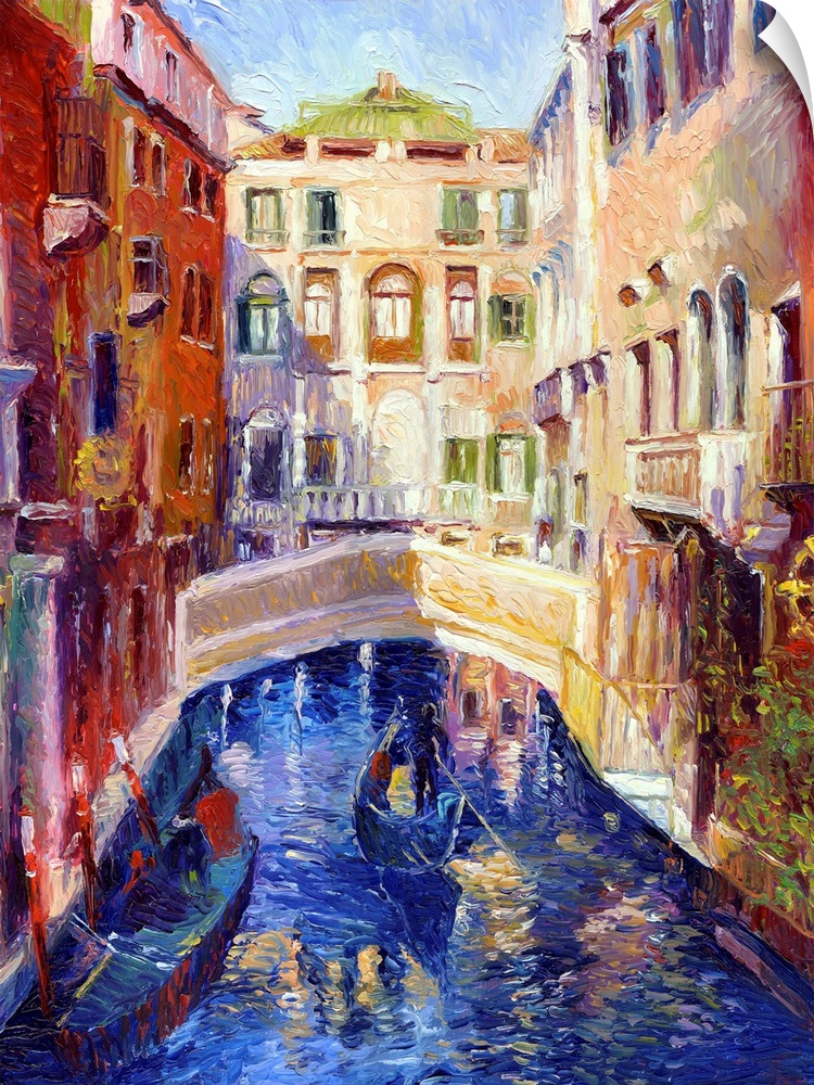 A canal in Venice with gondolas on it and houses on either side.