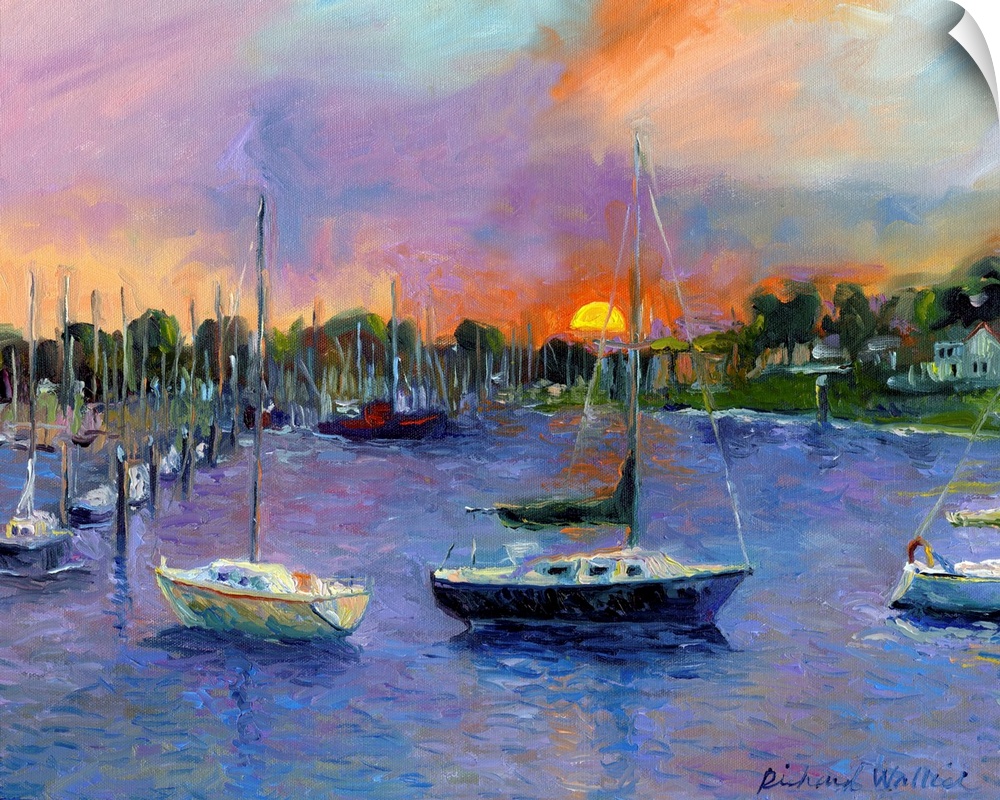 Sail boats in bay with sun setting in background.