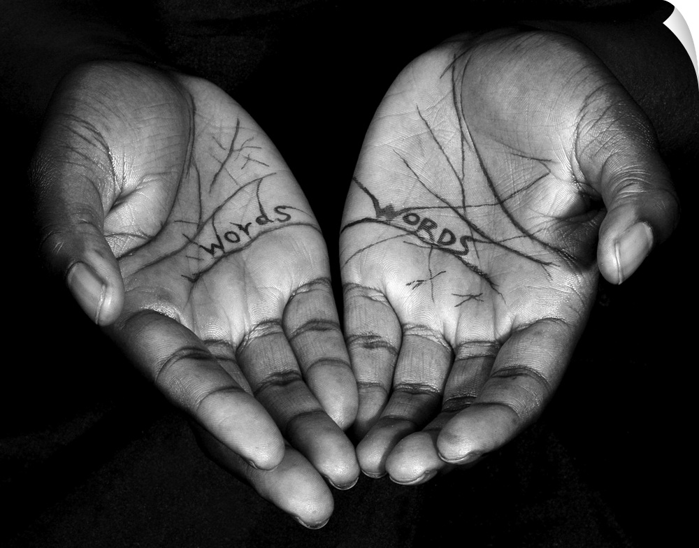 A high impact contemporary black and white photograph of a pair of hands feadruing the words 'words' inscribed on them