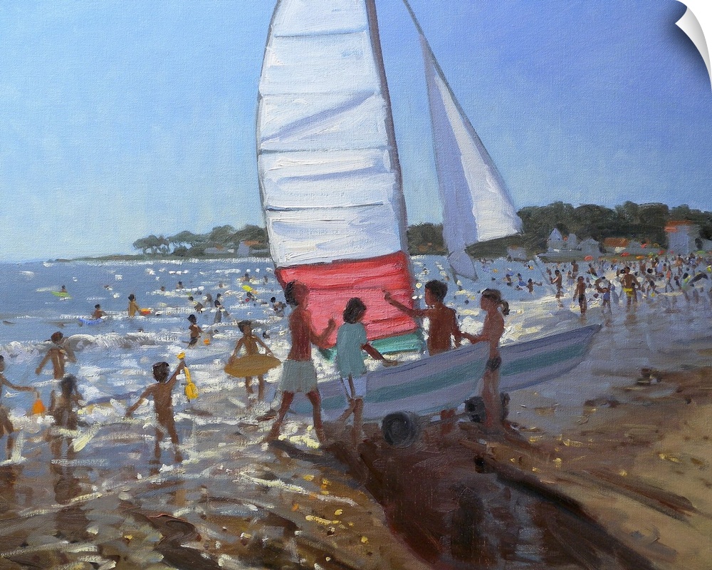 A beach is filled with lots of kids playing in the water and one group pushing a sail boat into it.