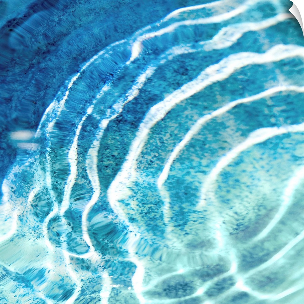 Square photograph of ripples in clear blue water.