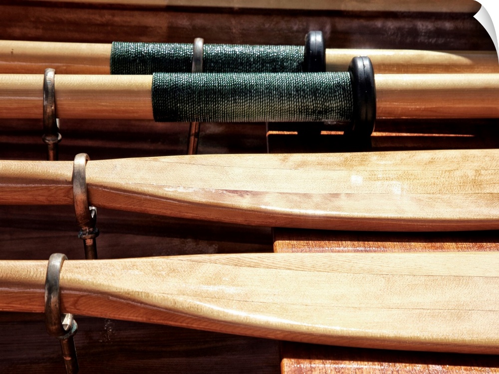 Close-up photograph of wooden oars laid out on a boat.