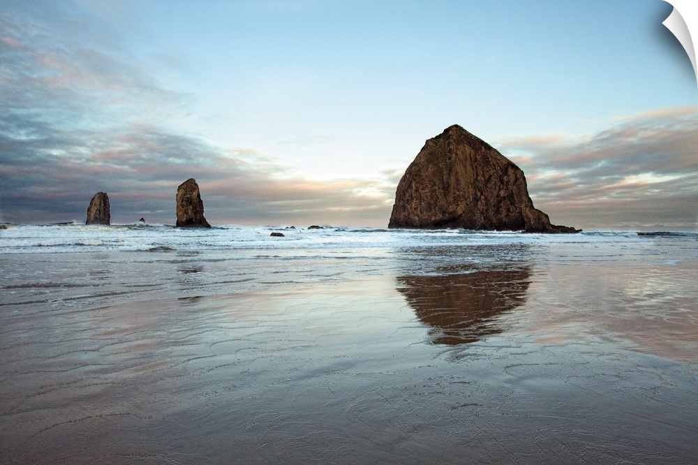 Photograph of large rocks along the coastline of a beach.