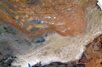 Alien red sand crawls over a bereft African plain