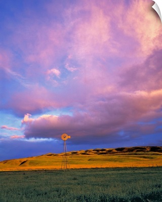 A windmill is dwarfed by enormous violet clouds in Ventura County, California