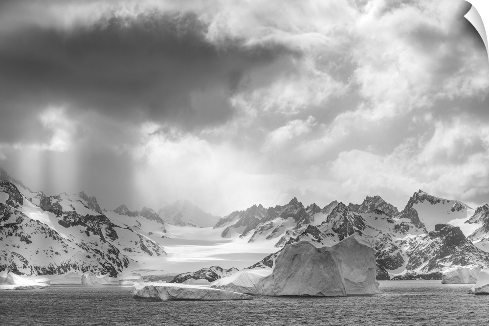 Antarctica, South Georgia island. Sunbeams light up icebergs and mountains.