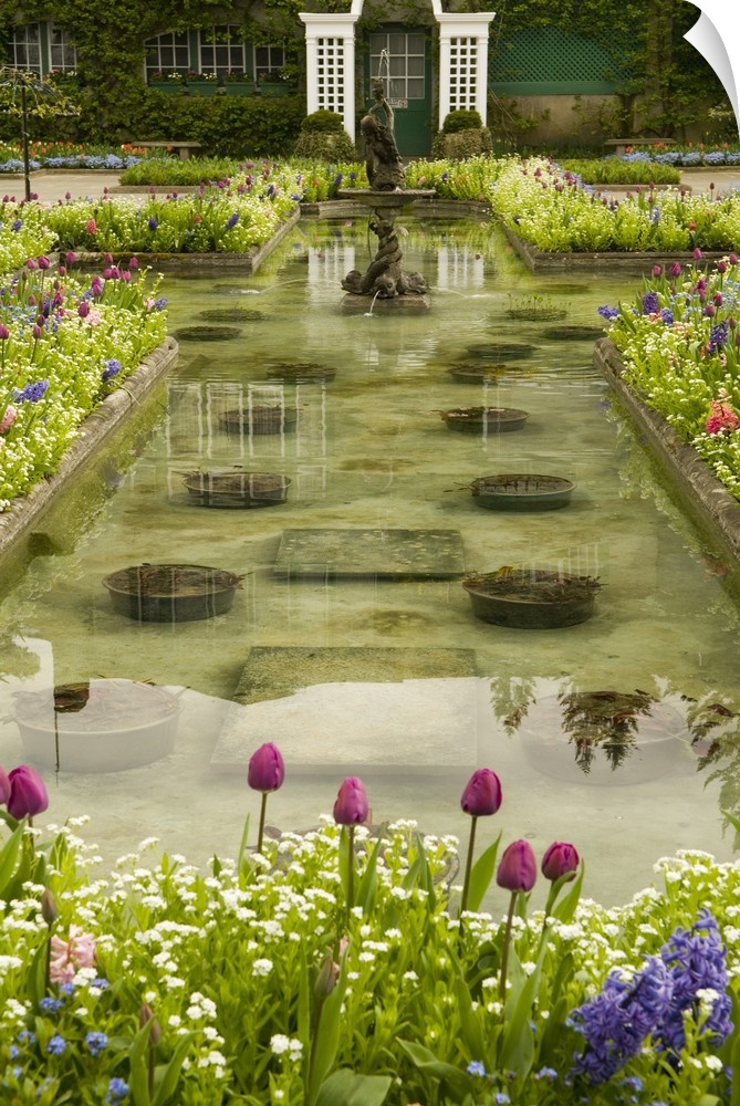 North America, Canada, British Columbia, Butchart Gardens.  Formal reflecting pool surrounded by profuse spriing bloom