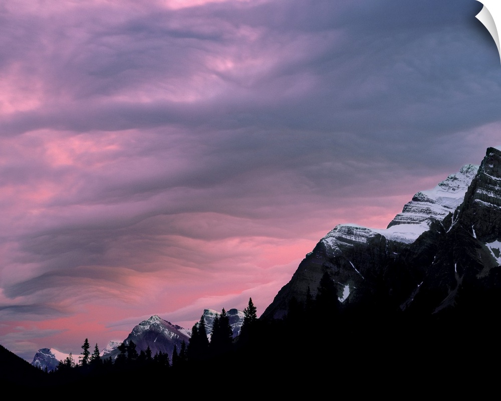 Canada, Alberta, Rocky Mountains. The setting sun colors the clouds above the Canadian Rockies, Alberta, Canada.