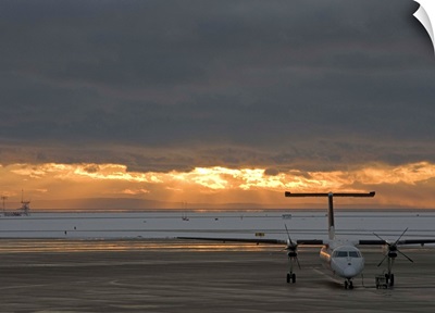 Canada, British Columbia, Vancouver, Dash 8 aircraft with sun lighting distant clouds