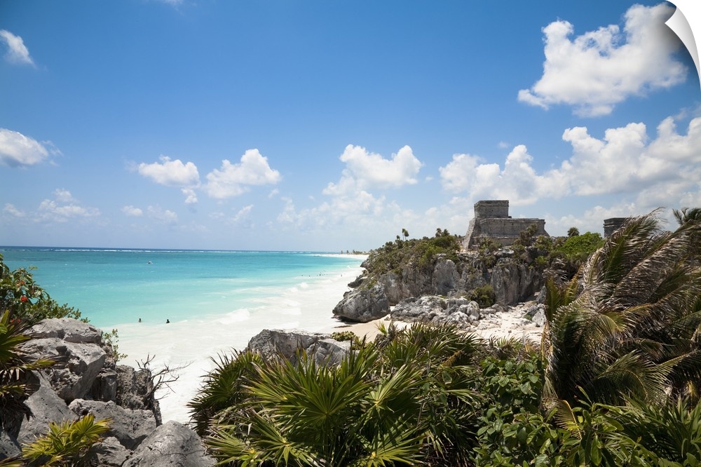 Cancun, Quintana Roo, Mexico. A white sand beach behind tropical foliage. An old stone structure can be seen on a hill in ...