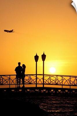 Caribbean, Aruba, Oranjestad, couple on bridge enjoying sunset