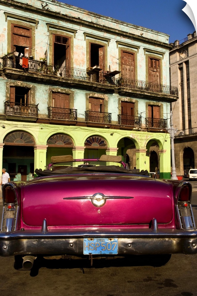 Classic 50s Buick colorful convertible auto in Havana Cuba Habana in front of old worn and colorful apartment buildings in...