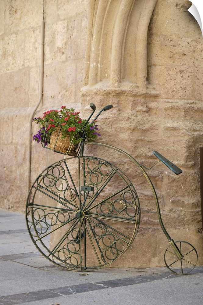 Cordoba, Spain. Bicycle planter in front of old stone building.