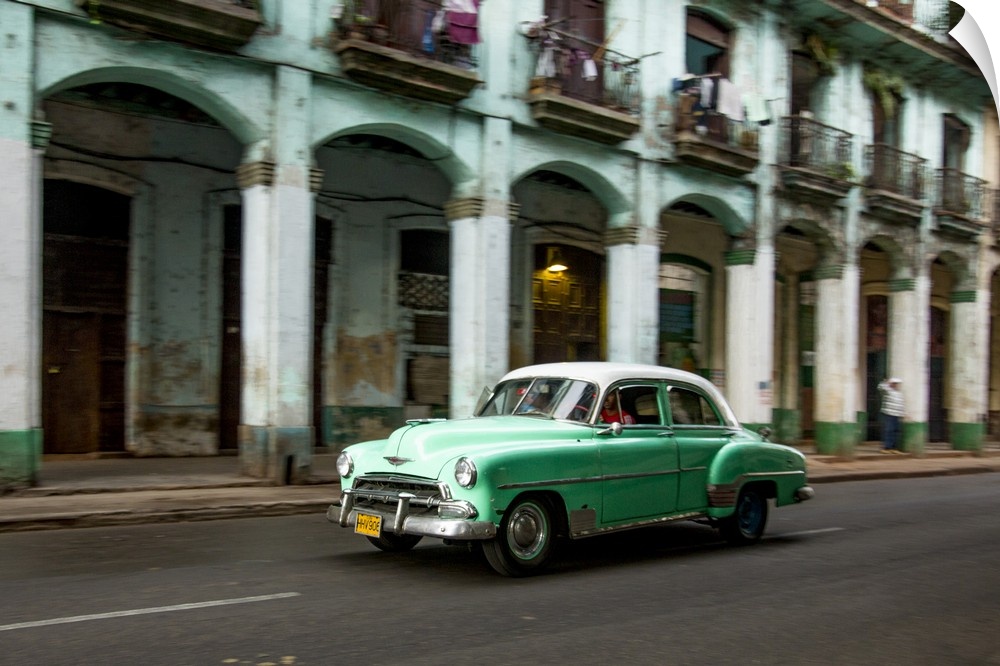 Cuba, Havana, classic green car and arches of colonial building. .