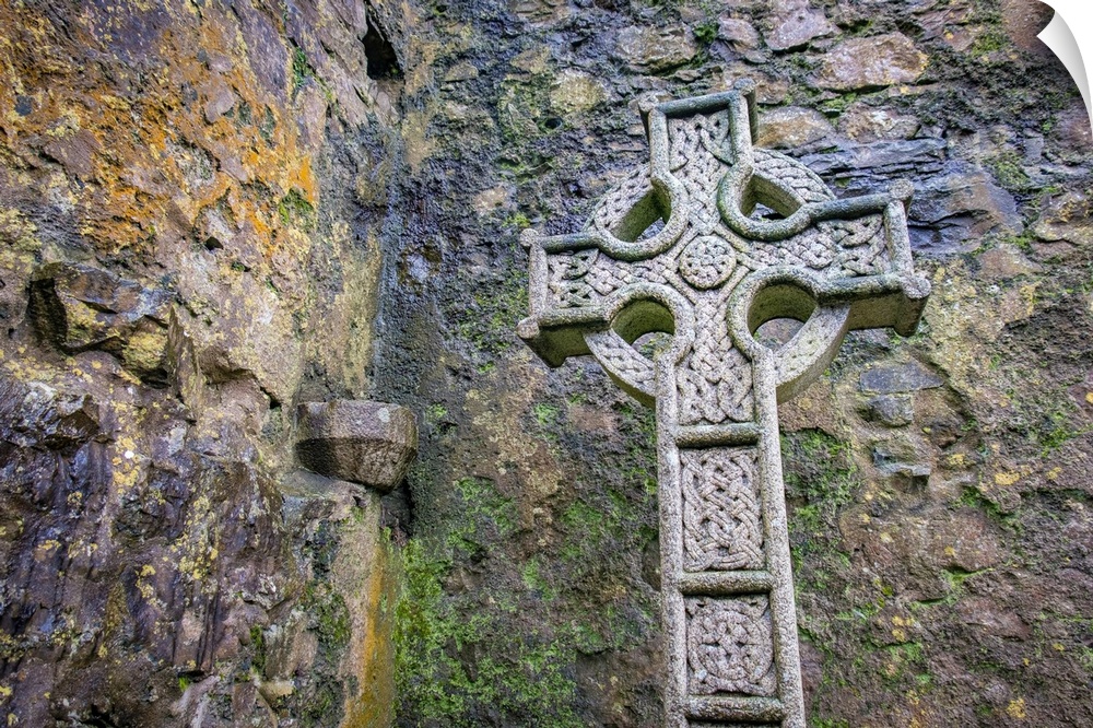 Elaborate Celtic cross marks a grave at a historic Irish church, County Mayo, Ireland.