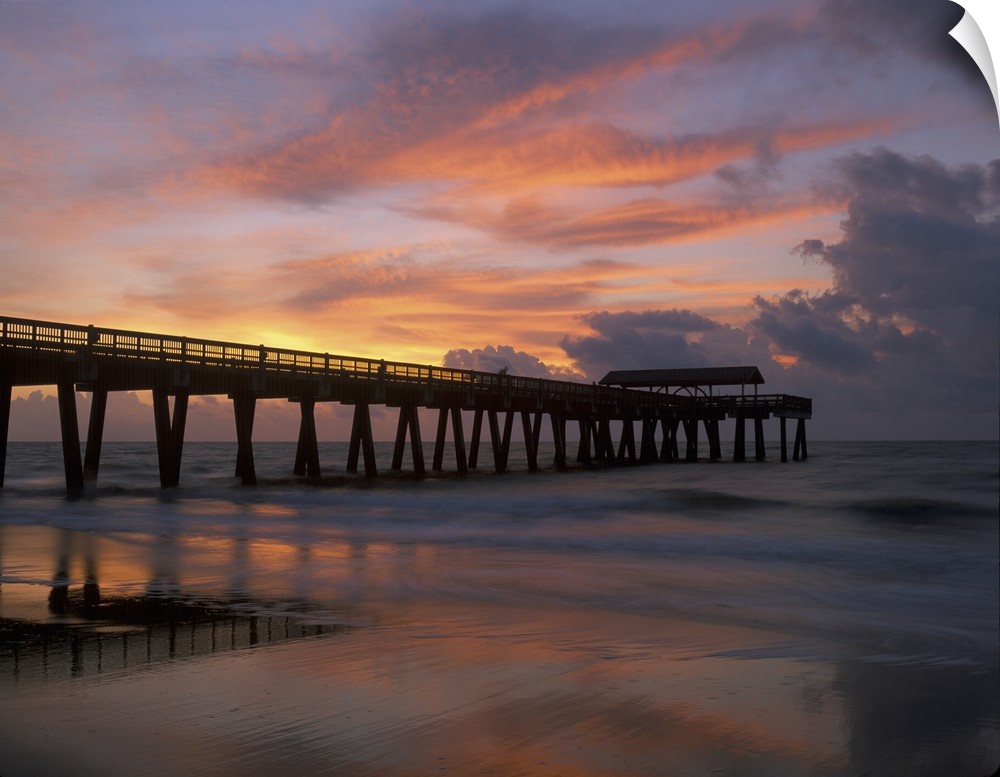 Georgia Tybee Island, pier at sunrise with reflections of clouds on beach.