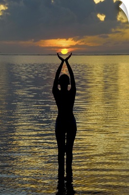 Indonesia, Bali. Woman silhouetted at sunrise on Sanur Beach