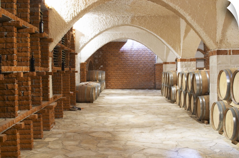 Wine cellar with bottle bins and oak barrels, arched vaulted ceiling. Matusko Winery. Potmje village, Dingac wine region, ...