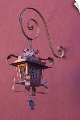 Mexico, San Miguel de Allende, ornate copper lamp hung from pink-purple wall