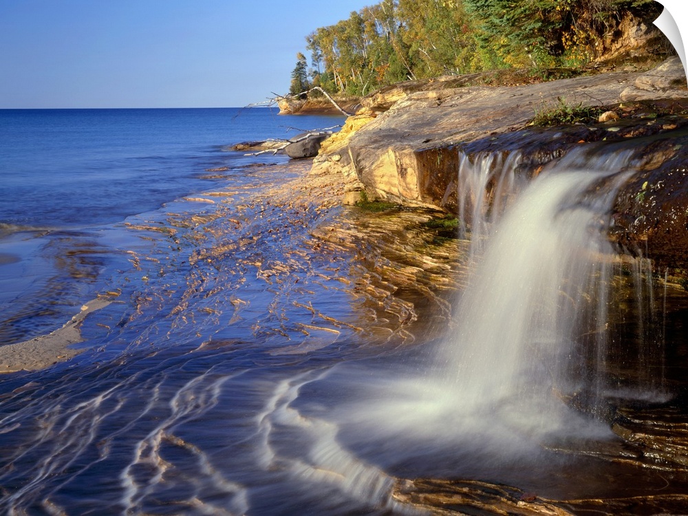 USA, Michigan, Pictured Rocks National Lakeshore, Small waterfall courses across sandstone shoreline at Miners Beach befor...