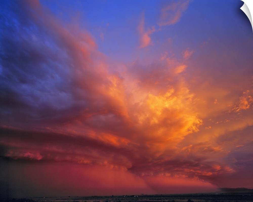 USA, Nevada. Storm clouds color with the setting sun over the Nevada desert.