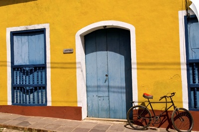 Old yellow building in colonial town of Trinidad Cuba with bike against wall