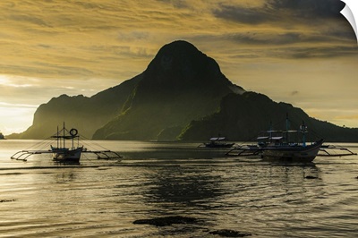 Outriggers at sunset in bay of El Nido, Palawan, Philippines