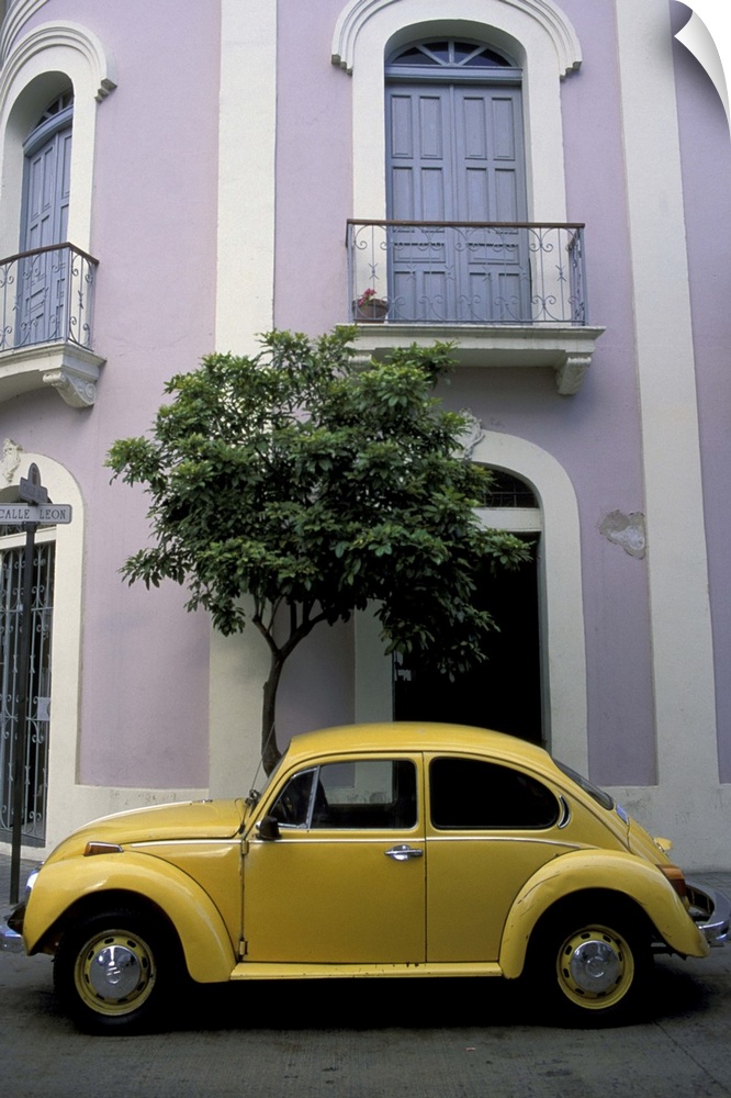 Puerto Rico, Ponce, Historic District. 19th century pink and white house with yellow VW Beetle parked in front.
