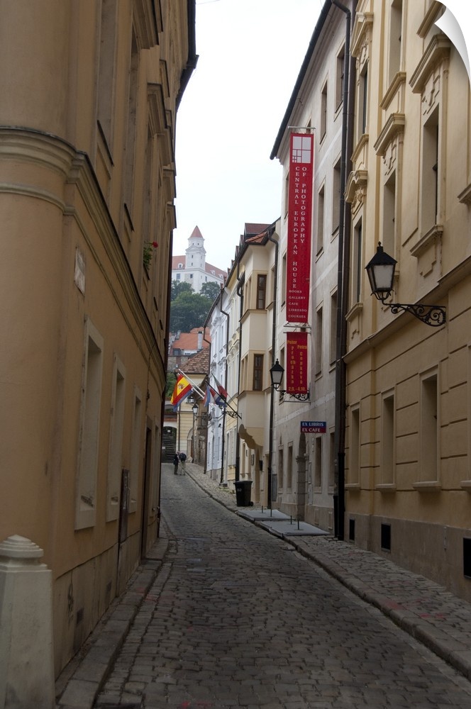 Slovakia, Bratislava. Narrow street in historic district with view of Bratislava Castle in distance.