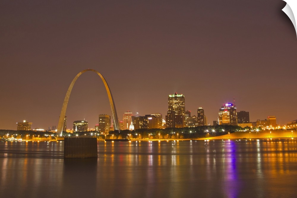 The Gateway Arch and St Louis skyline reflect into the Mississippi River at dusk in St Louis, Missouri, USA