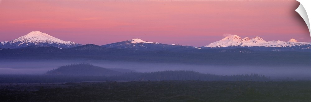 USA, Oregon, Cascades Range. The pink blanket of sunrise warms the Oregon Cascades, as seen from Lava Butte.