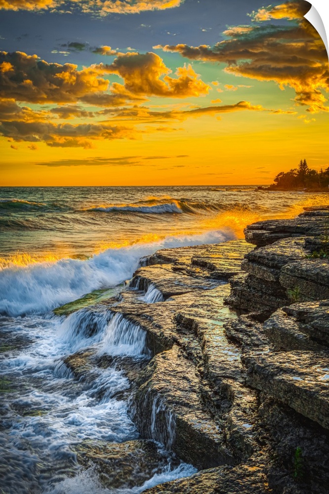 USA, New York, Lake Ontario. Sunset waves on rocky shoreline. United States, New York.