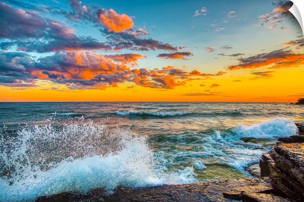 USA, New York, Lake Ontario. Sunset waves on rocky shoreline. United States, New York.