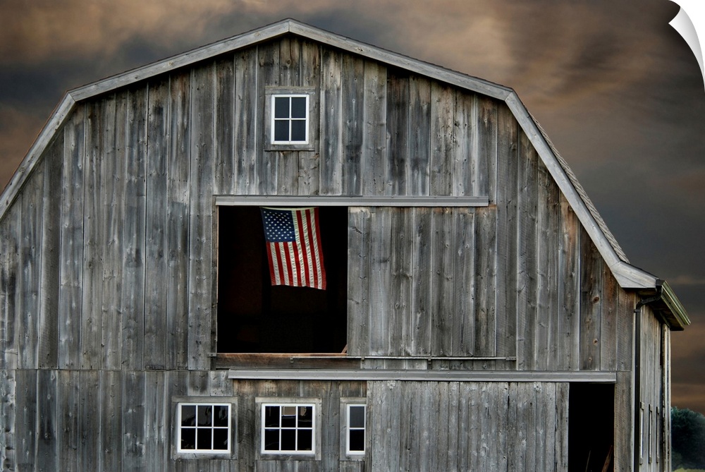 Flag flying in hay loft of old barn.