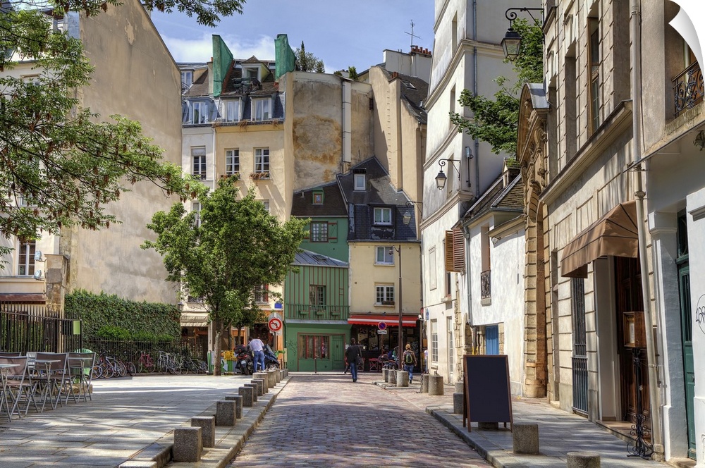 View of narrow cobbled street among traditional Parisian buildings in Paris, France.