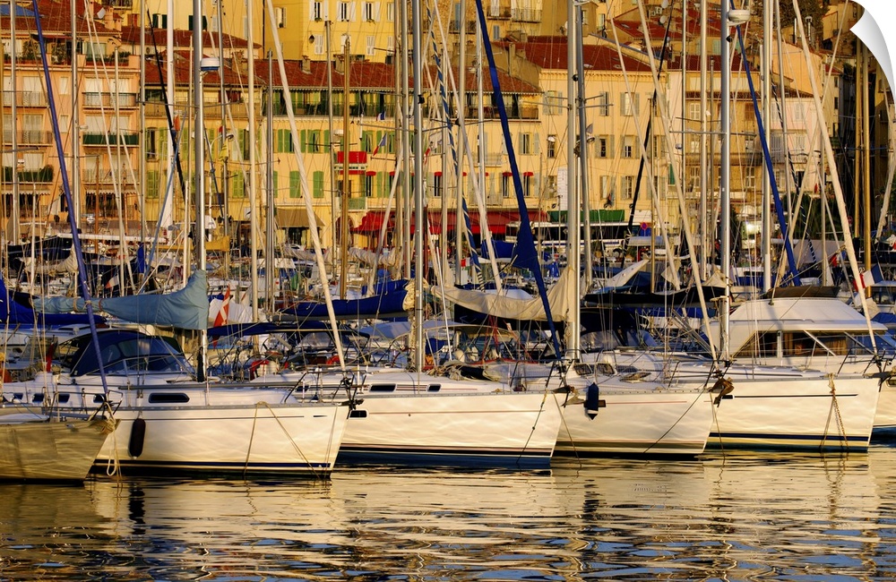 The Vieux Port (old port) in the city of Cannes in the French riviera as the first rays of the morning sun illuminate the ...