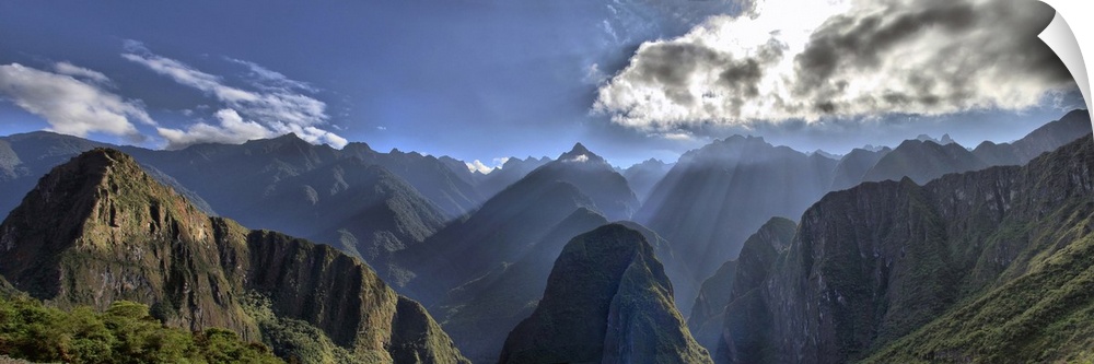 View of Andes Mountain Range from Machu Picchu. Beautiful scenery with sun rays shining through the mountains peaks.